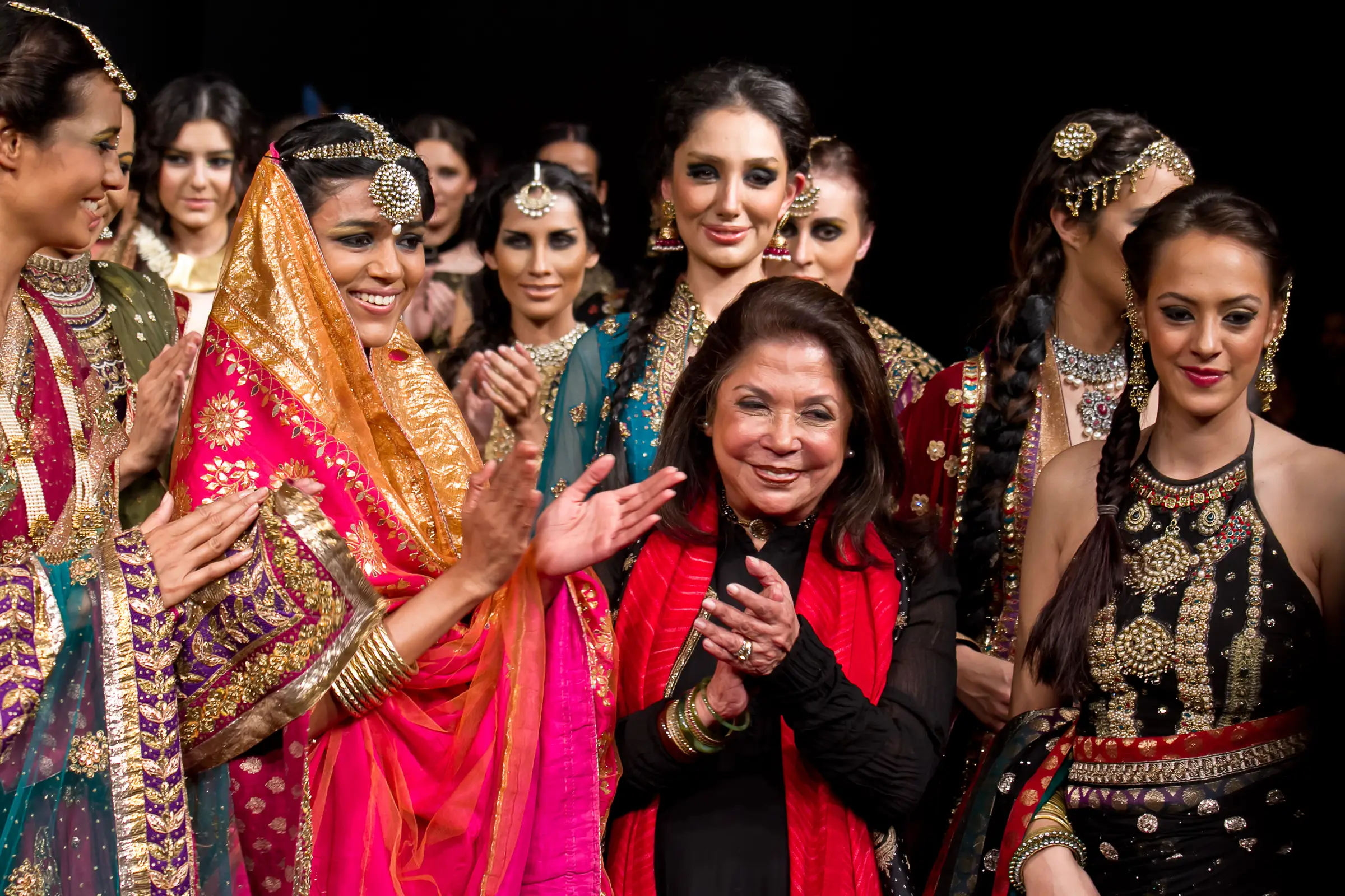Designer applauding among models in bridal wear at the Bangalore Fashion Week finale, photographed by Vivek Pankaj