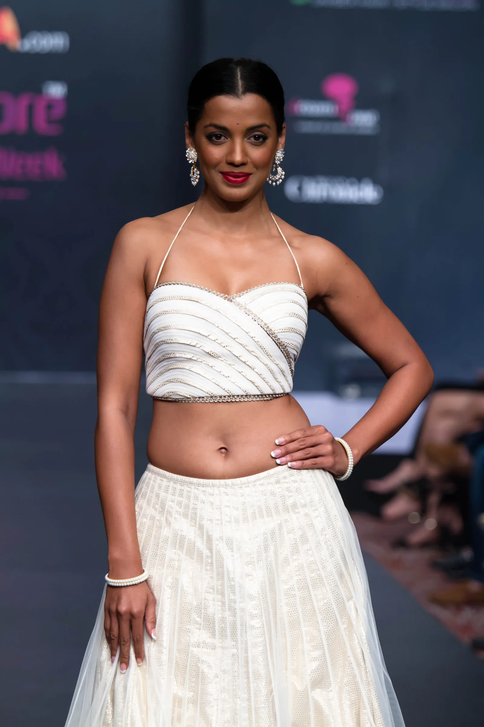 Model in a white corset-style crop top and skirt on the runway at Bangalore Fashion Week, photographed by Vivek Pankaj
