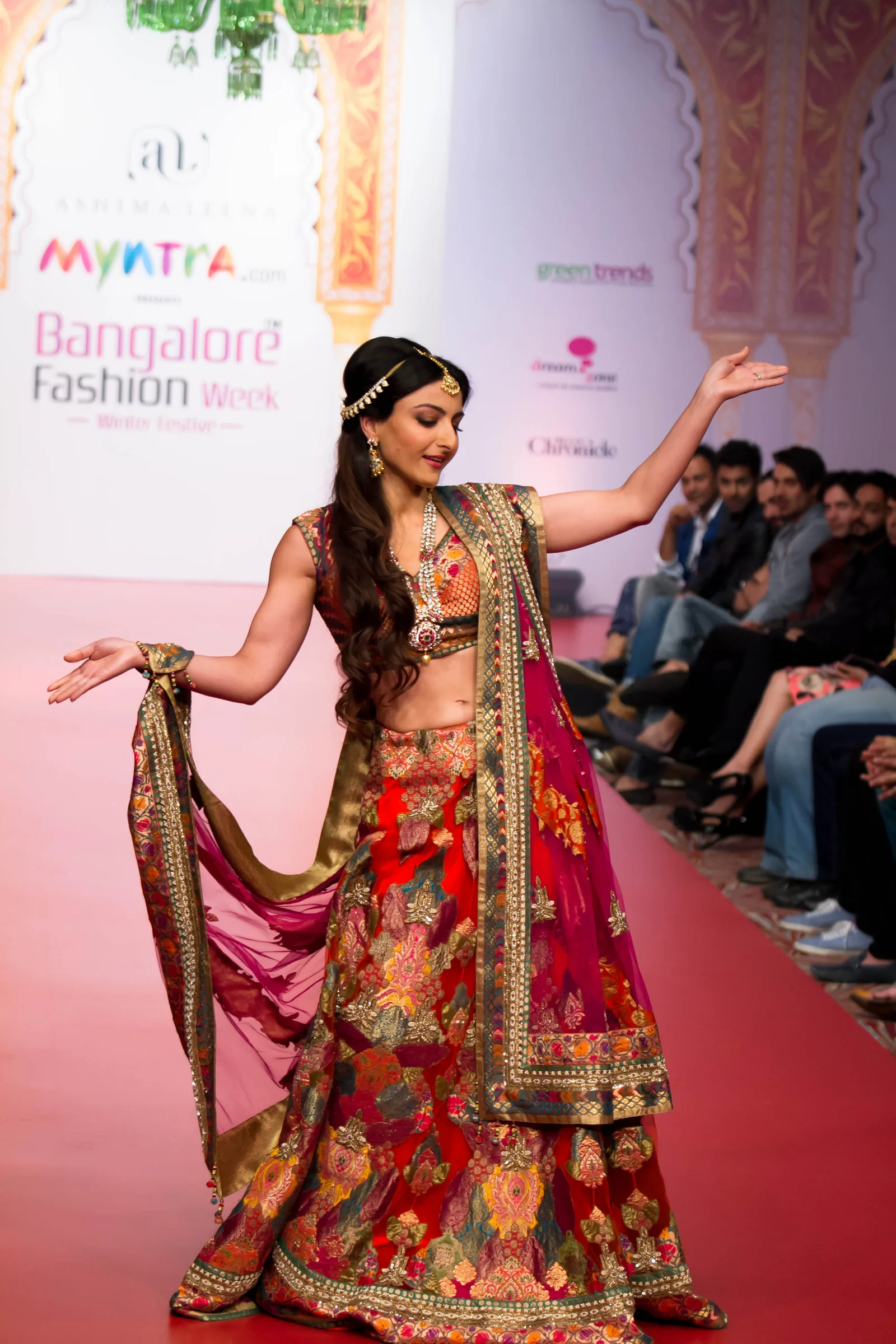 Soha Ali Khan turning on the runway in an embroidered red and gold lehenga at Bangalore Fashion Week Winter Festive, photographed by Vivek Pankaj