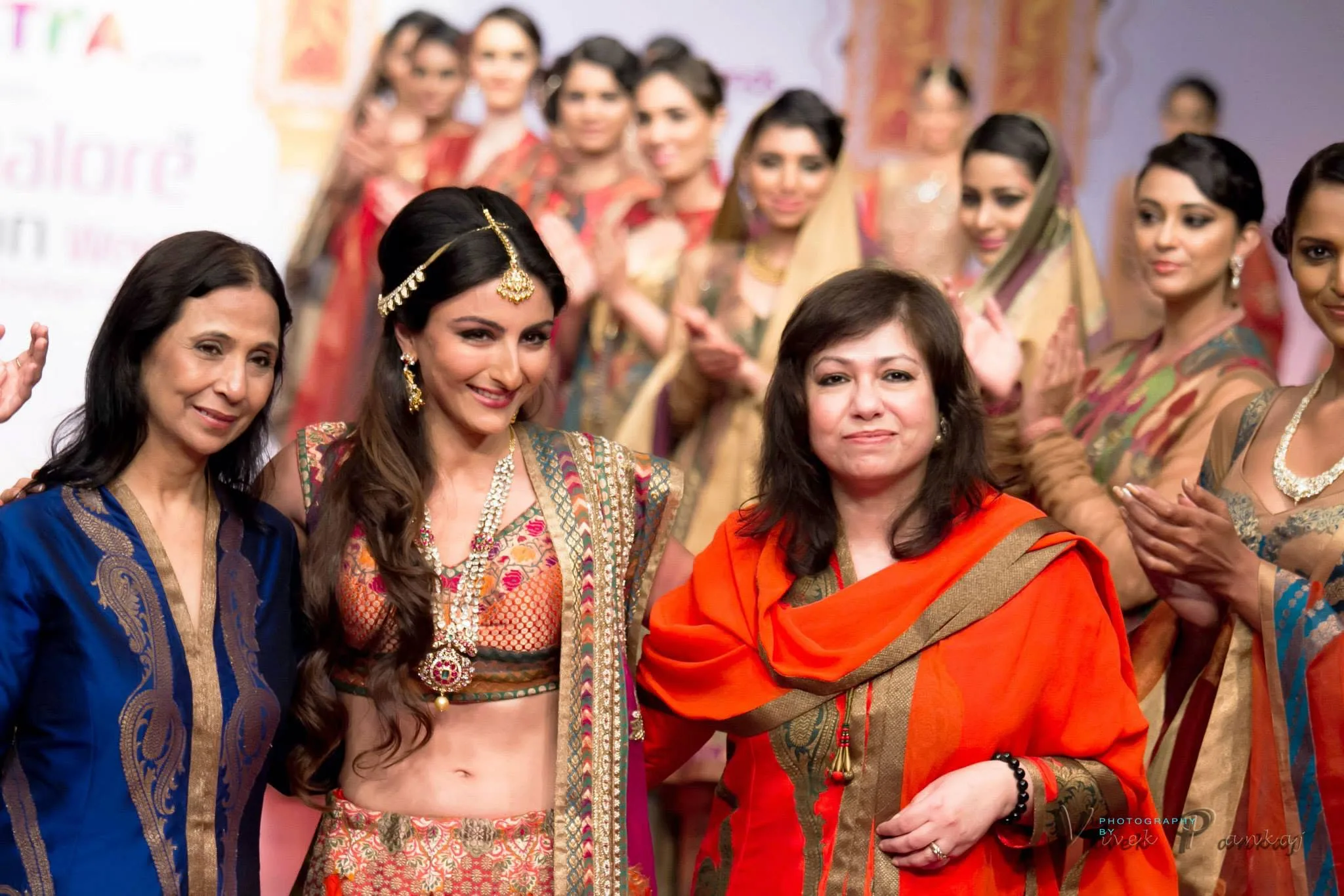 Soha Ali Khan walking the runway finale at Bangalore Fashion Week with the designers, models in Indian festive wear applauding behind them, photographed by Vivek Pankaj